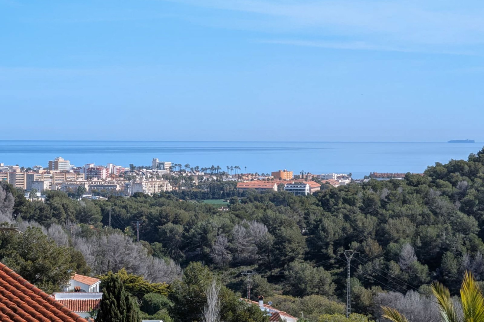 Vue panoramique surélevée depuis la parcelle sur la mer Méditerranée, le littoral de Jávea et les collines boisées environnantes.