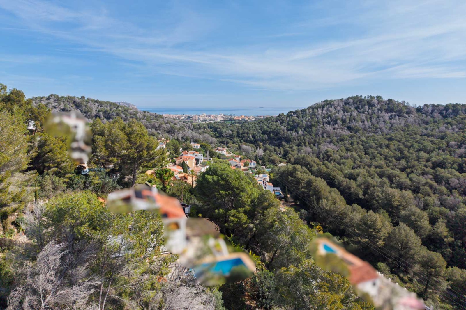 Vues panoramiques depuis le terrain sur les collines boisées de pins s'étendant jusqu'à la mer Méditerranée et la ville côtière de Jávea.