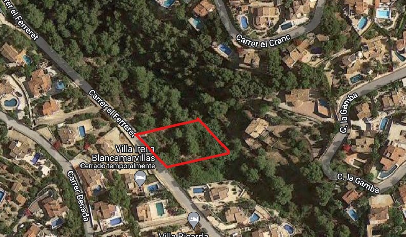 Vue aérienne par satellite du terrain de 826 m2 délimité en rouge sur la Carrer el Ferreret, illustrant son environnement boisé et les villas voisines.