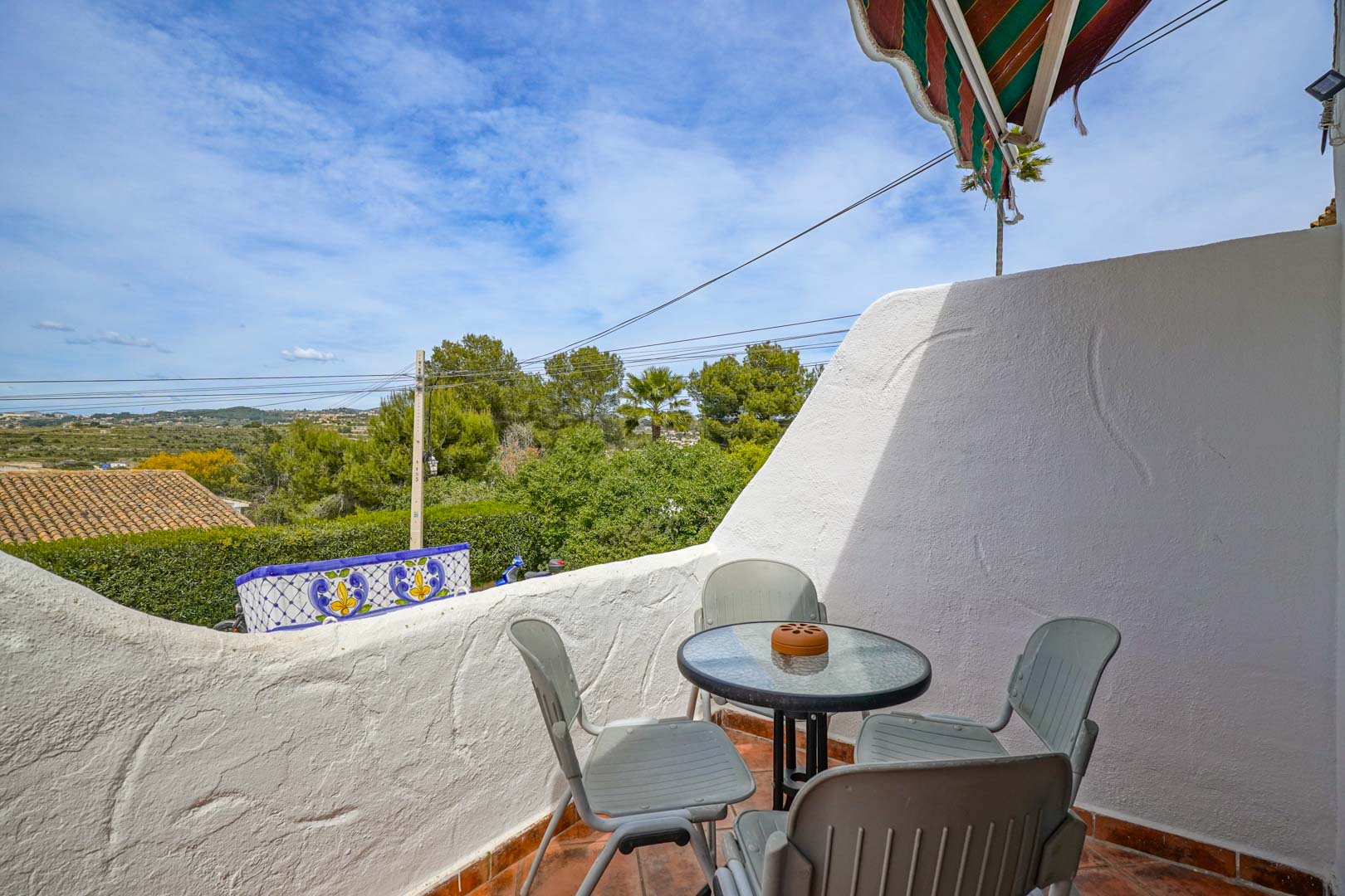 Terrasse extérieure avec sol en terre cuite et coin salon, offrant une vue dégagée sur la vallée et la végétation environnante de Moraira.