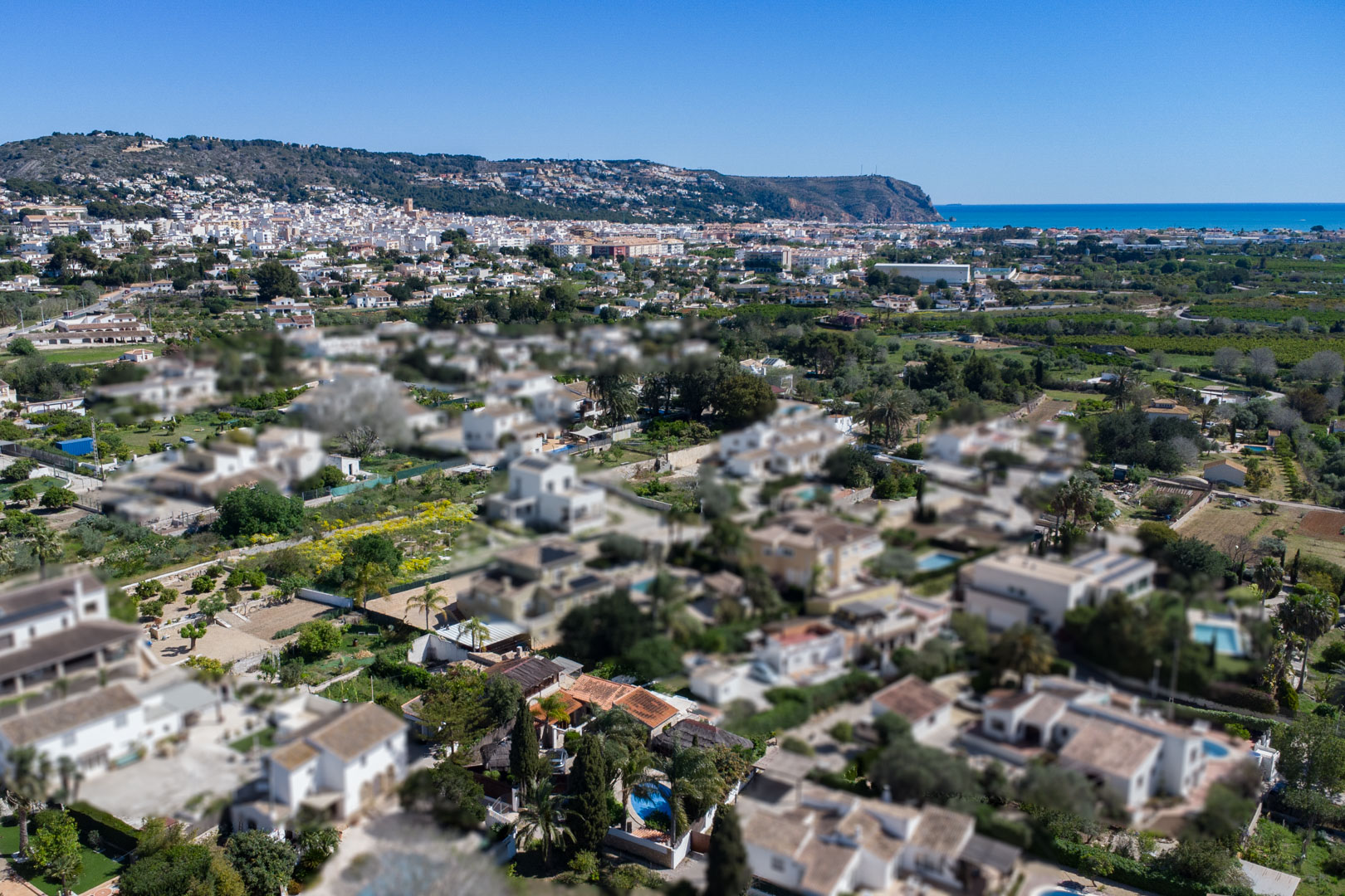 Vue aérienne de la zone résidentielle à Jávea, illustrant la proximité du centre-ville, de la côte méditerranéenne et des collines environnantes.