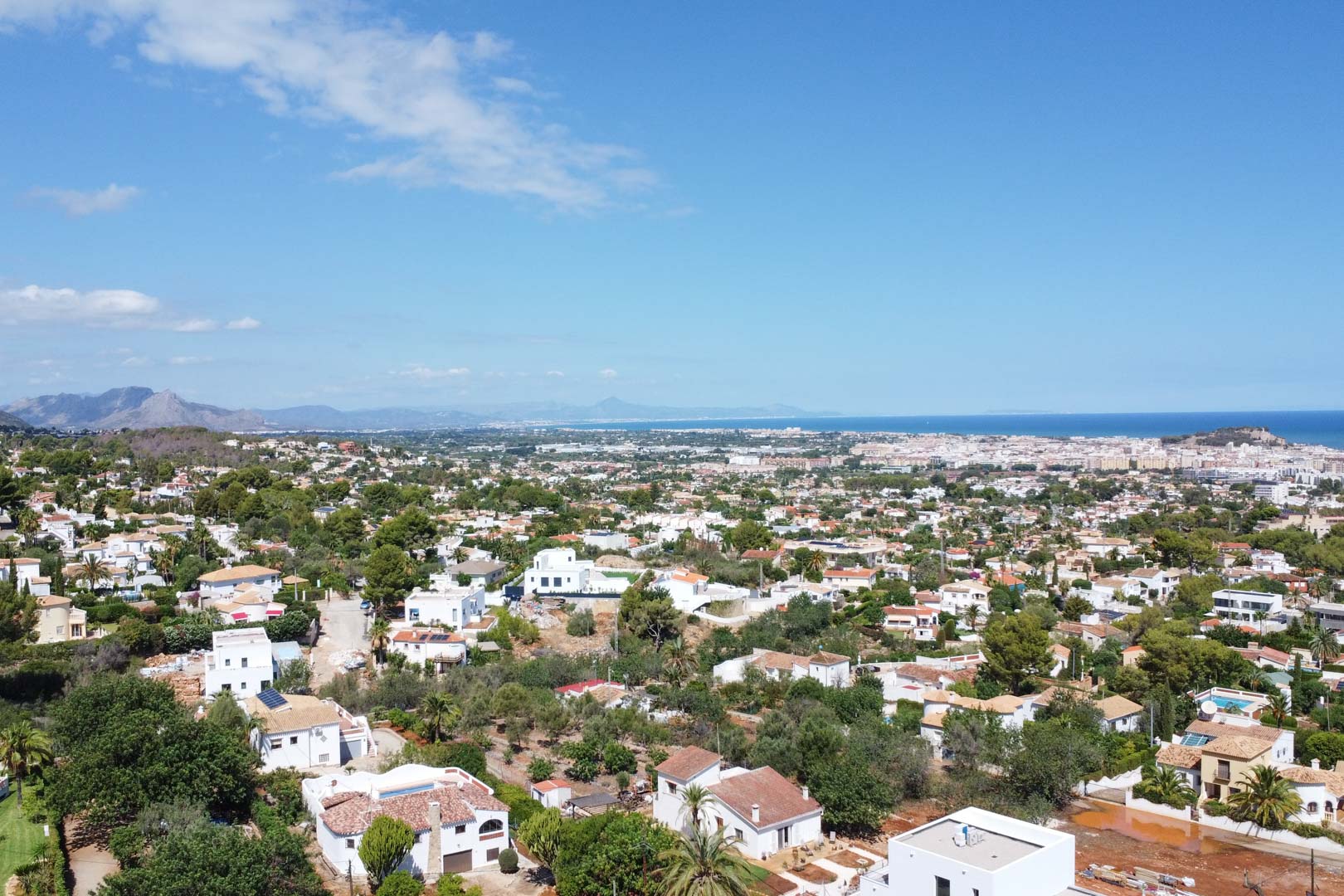 Vue aérienne panoramique du quartier résidentiel de Dénia, illustrant la proximité de la mer Méditerranée et l'intégration des villas dans le paysage.