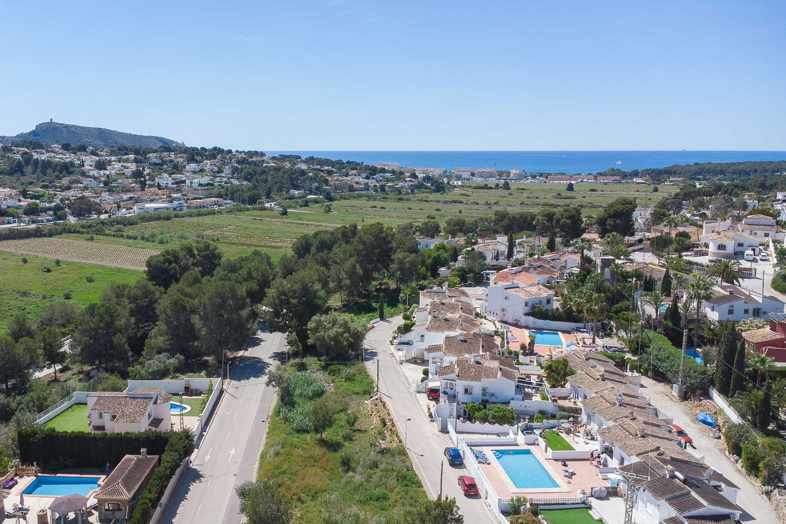 Vue aérienne panoramique de Moraira révélant le littoral méditerranéen, les espaces verts environnants et le quartier résidentiel paisible de la Costa Blanca.