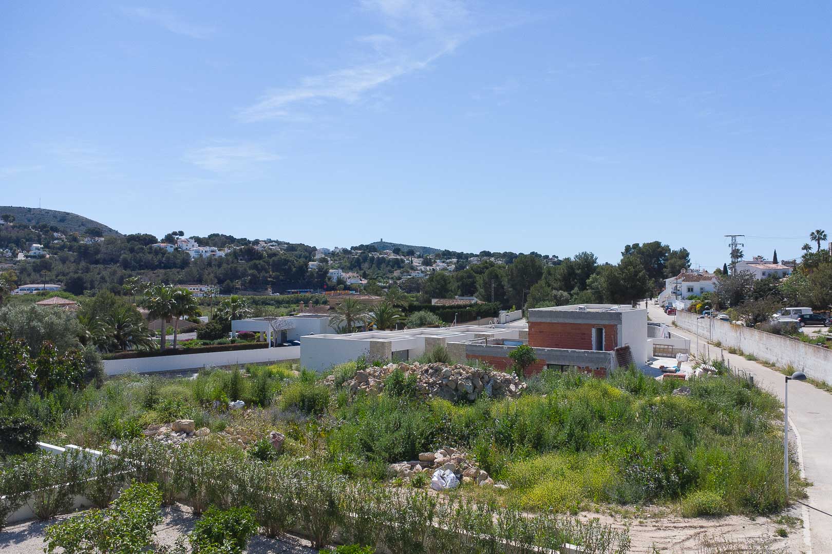 Vue extérieure de la villa en construction, mettant en valeur sa structure moderne et son intégration dans le paysage méditerranéen de Moraira.
