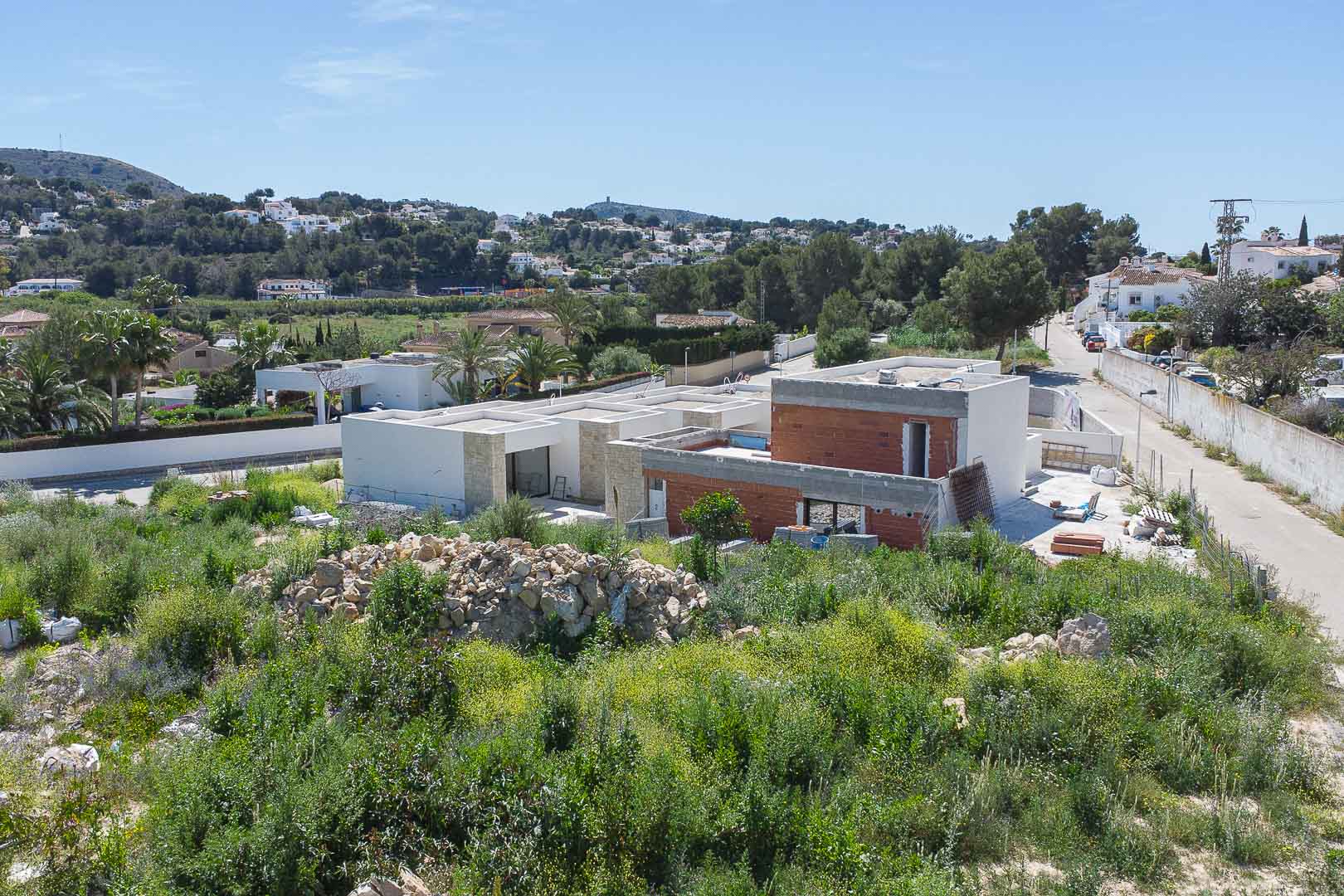 Vue extérieure de la villa en construction, mettant en valeur son architecture moderne, ses façades en pierre naturelle et sa structure intégrée au paysage méditerranéen.
