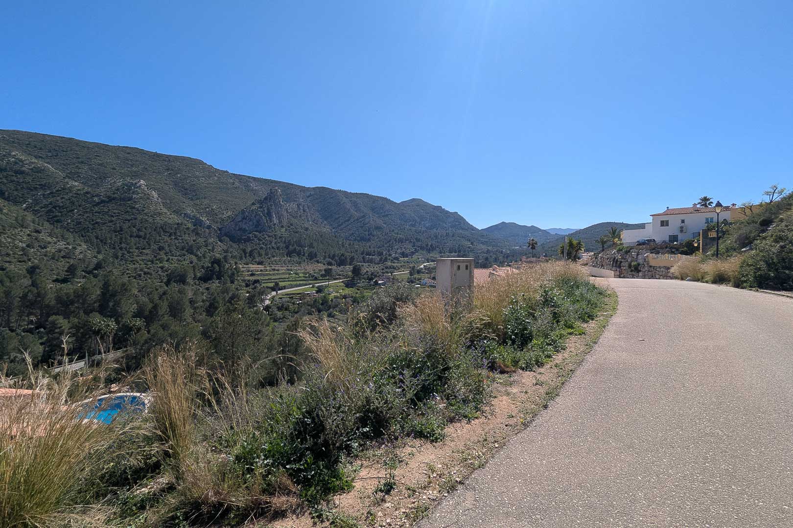 Vues panoramiques depuis le chemin d'accès sur la vallée et les montagnes environnantes de Pedreguer par une journée ensoleillée.