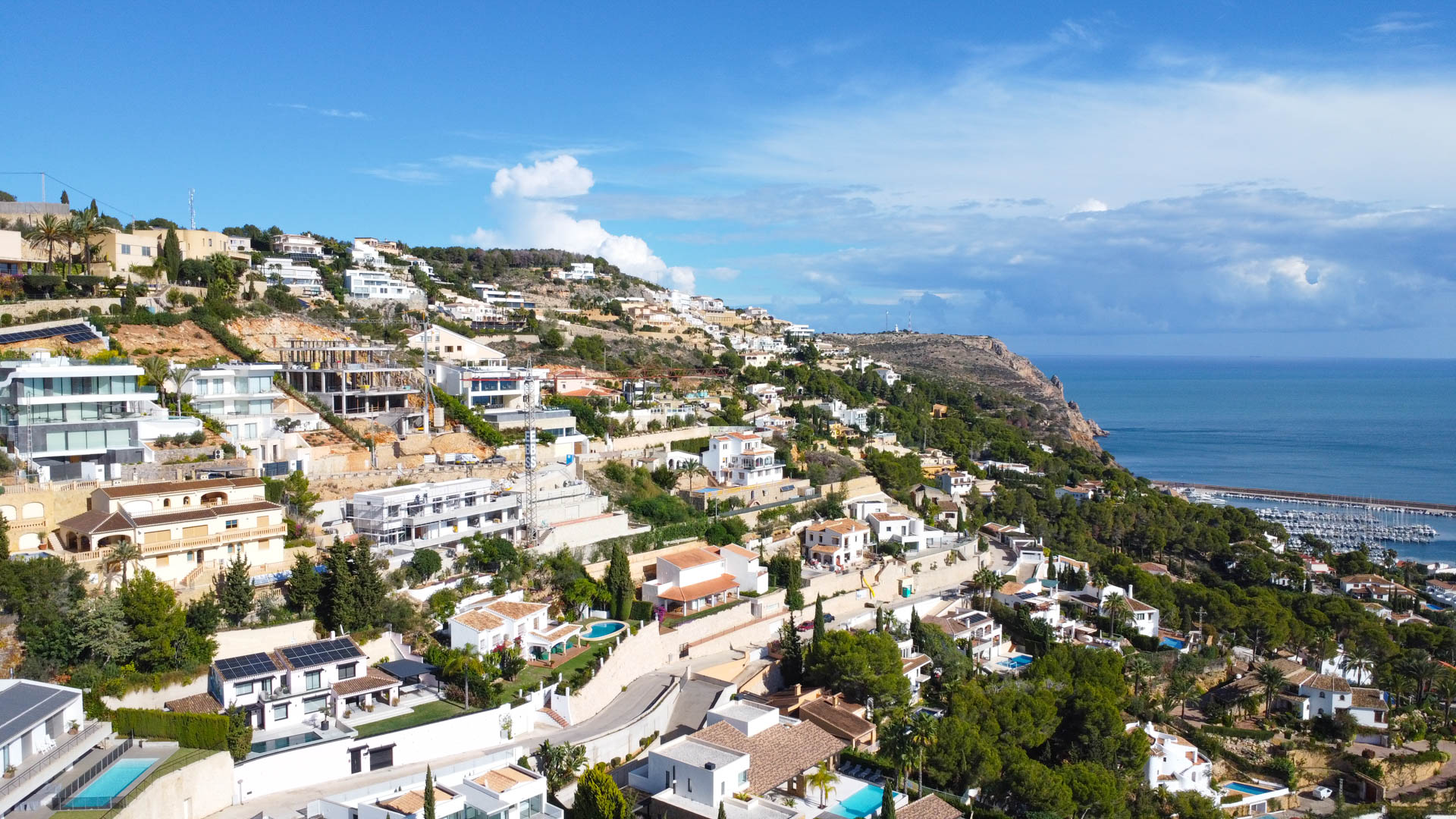 Vue aérienne panoramique du quartier résidentiel La Corona à Jávea, offrant une perspective sur le port de plaisance et la mer Méditerranée.