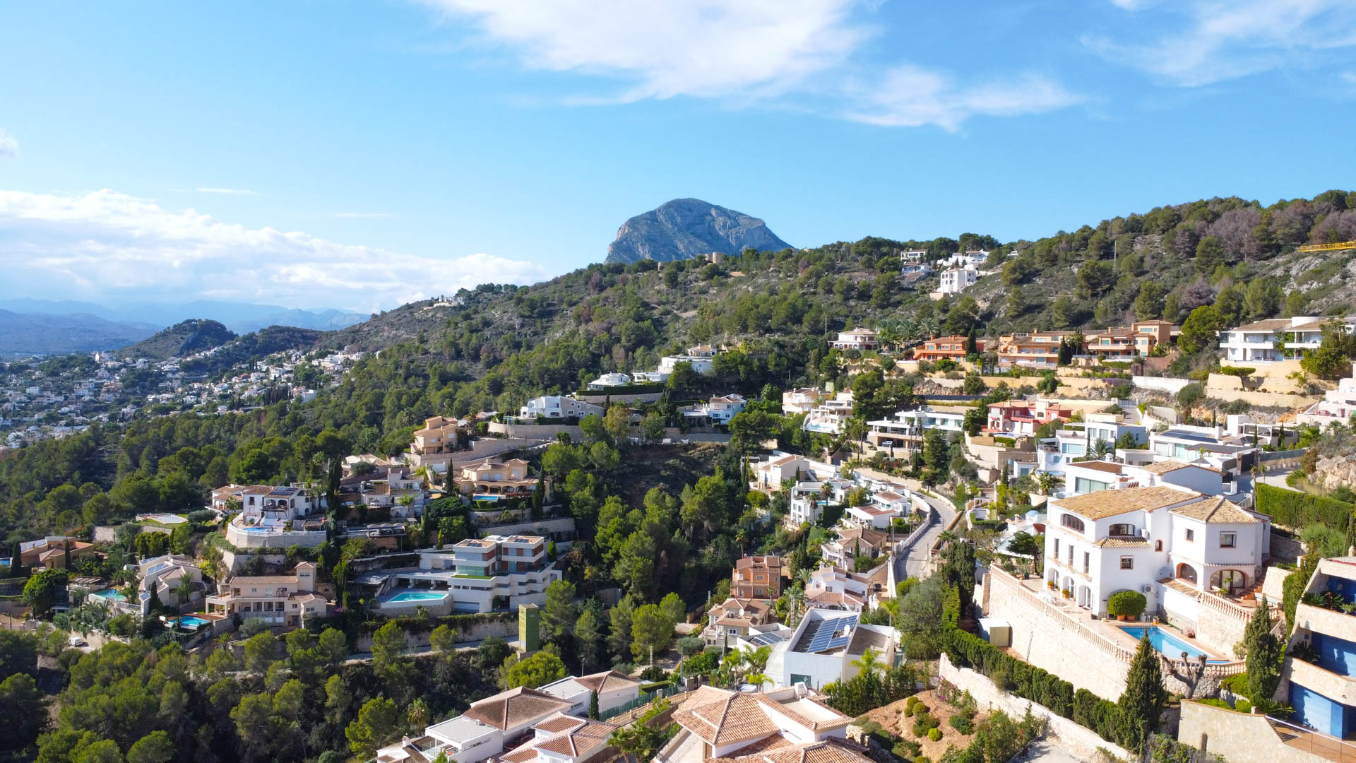 Vue aérienne du quartier de La Corona à Jávea, illustrant les villas méditerranéennes sur la colline avec le mont Montgó en arrière-plan.