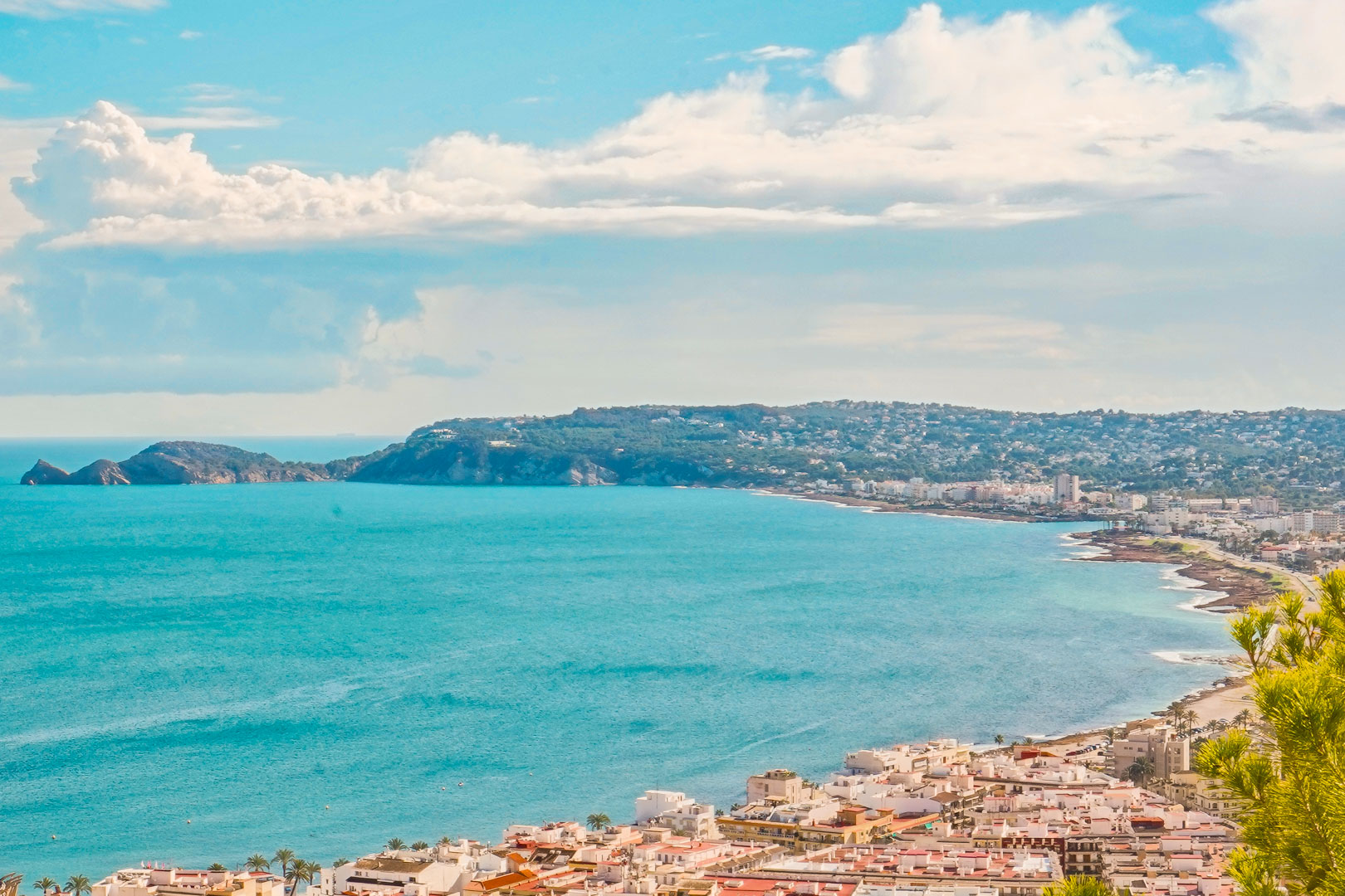 Vue panoramique sur la baie de Jávea depuis La Corona, illustrant l'architecture côtière et le promontoire du Cap Negre bordant la mer Méditerranée.