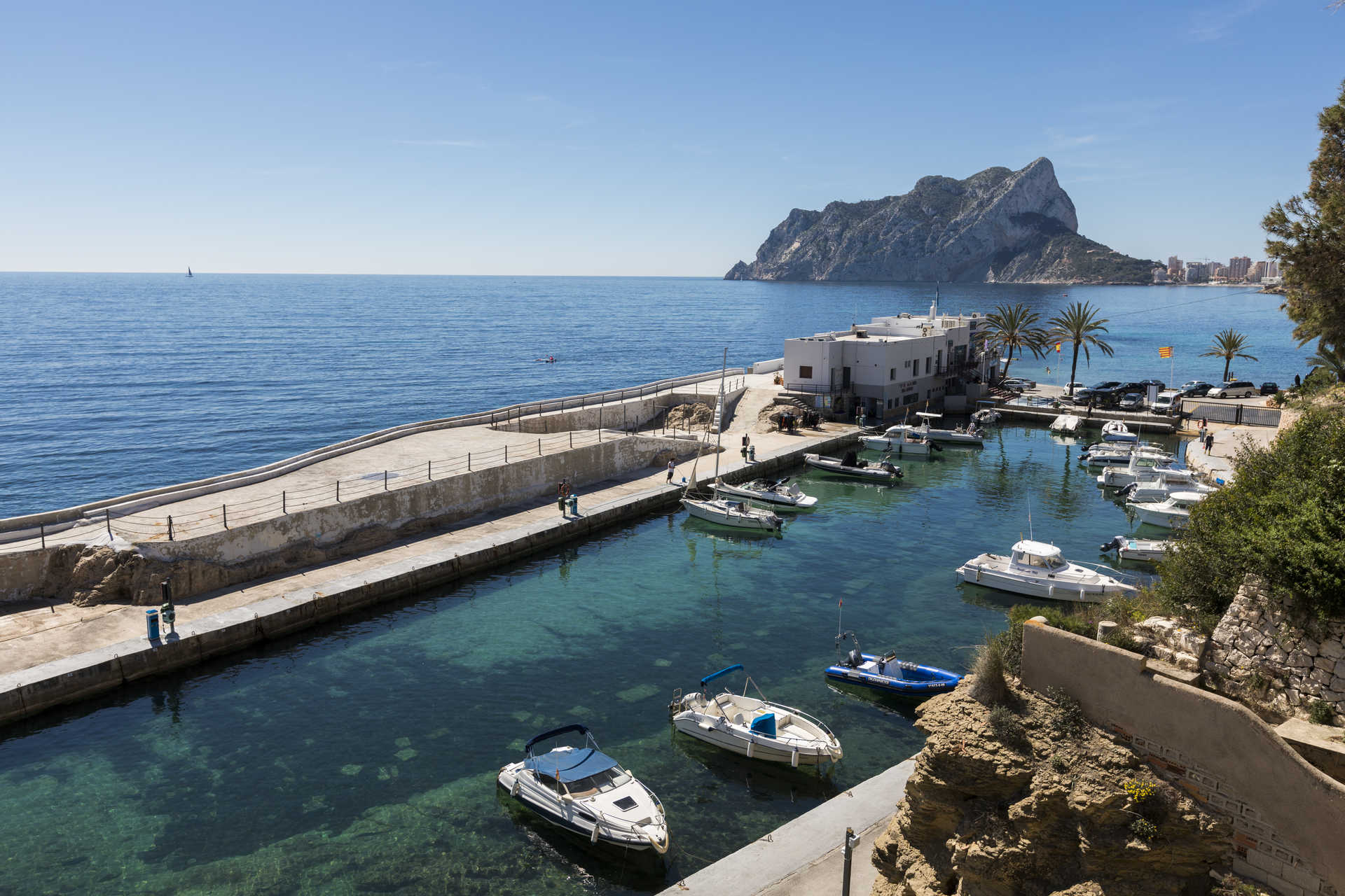 Vue panoramique sur le port de plaisance voisin avec le Peñón de Ifach en arrière-plan, illustrant les eaux cristallines et la proximité de la villa avec la côte méditerranéenne.
