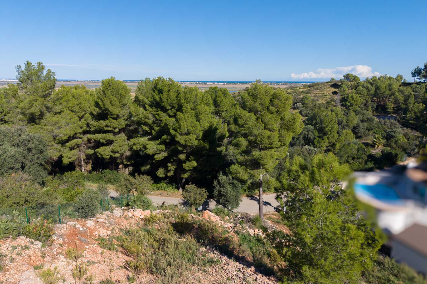 Vues panoramiques surélevées depuis le terrain sur la mer Méditerranée et le parc naturel de la Marjal, entouré de pinèdes et de végétation locale.