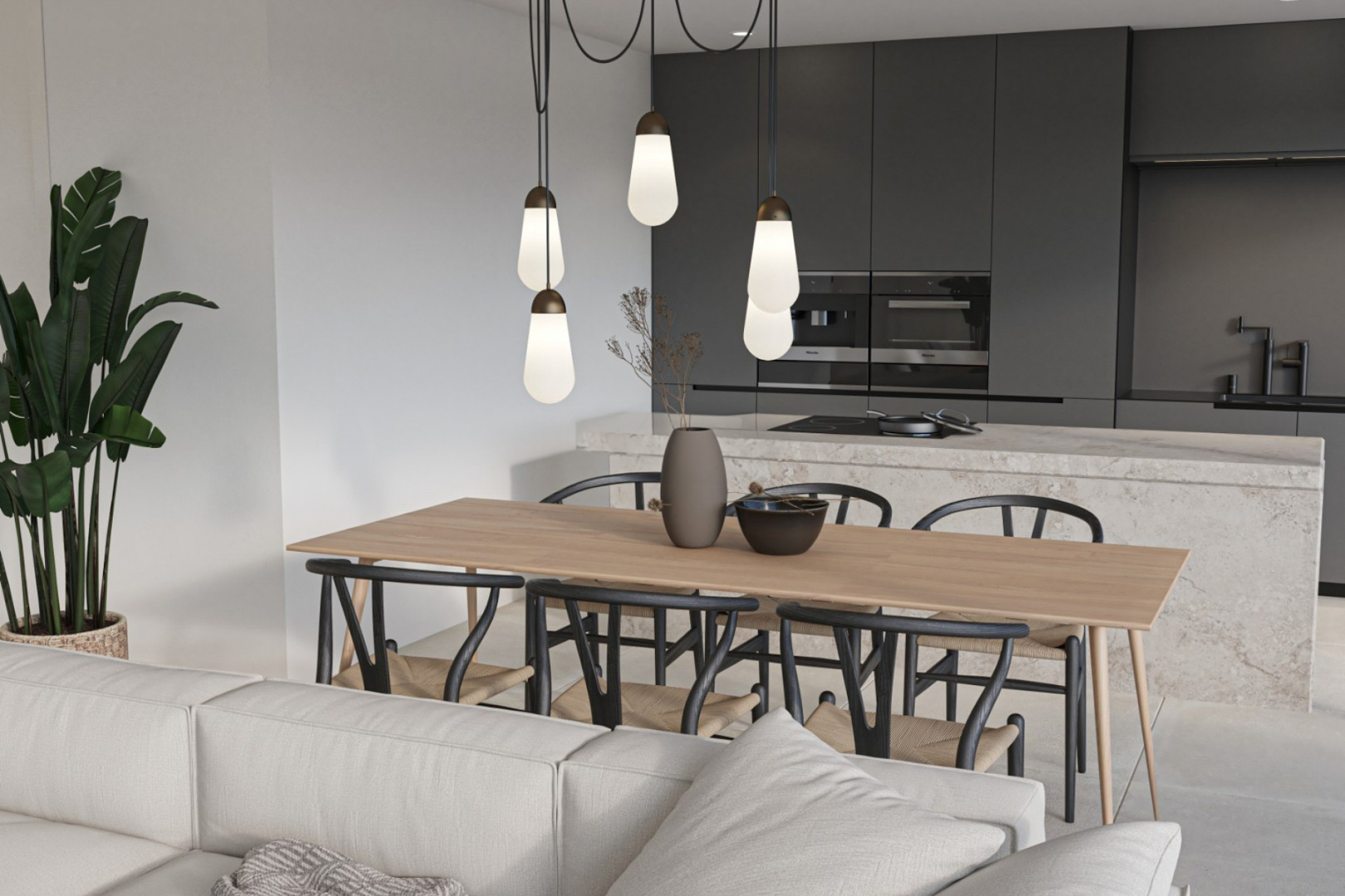 Espace dînatoire et cuisine moderne avec îlot en pierre naturelle, meubles gris anthracite, électroménager encastré et luminaires suspendus design.