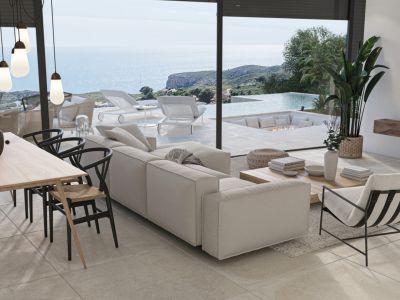 Salon lumineux avec vue mer, coin repas avec chaises design et accès à une terrasse avec piscine à débordement.