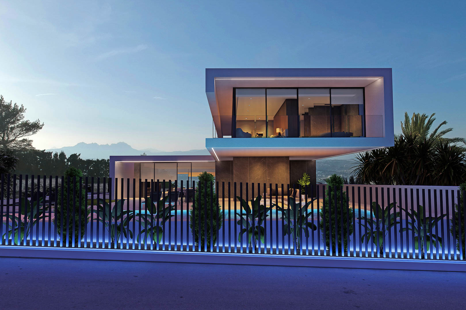 Vue nocturne extérieure de la villa, avec une clôture illuminée et un aperçu de la piscine.