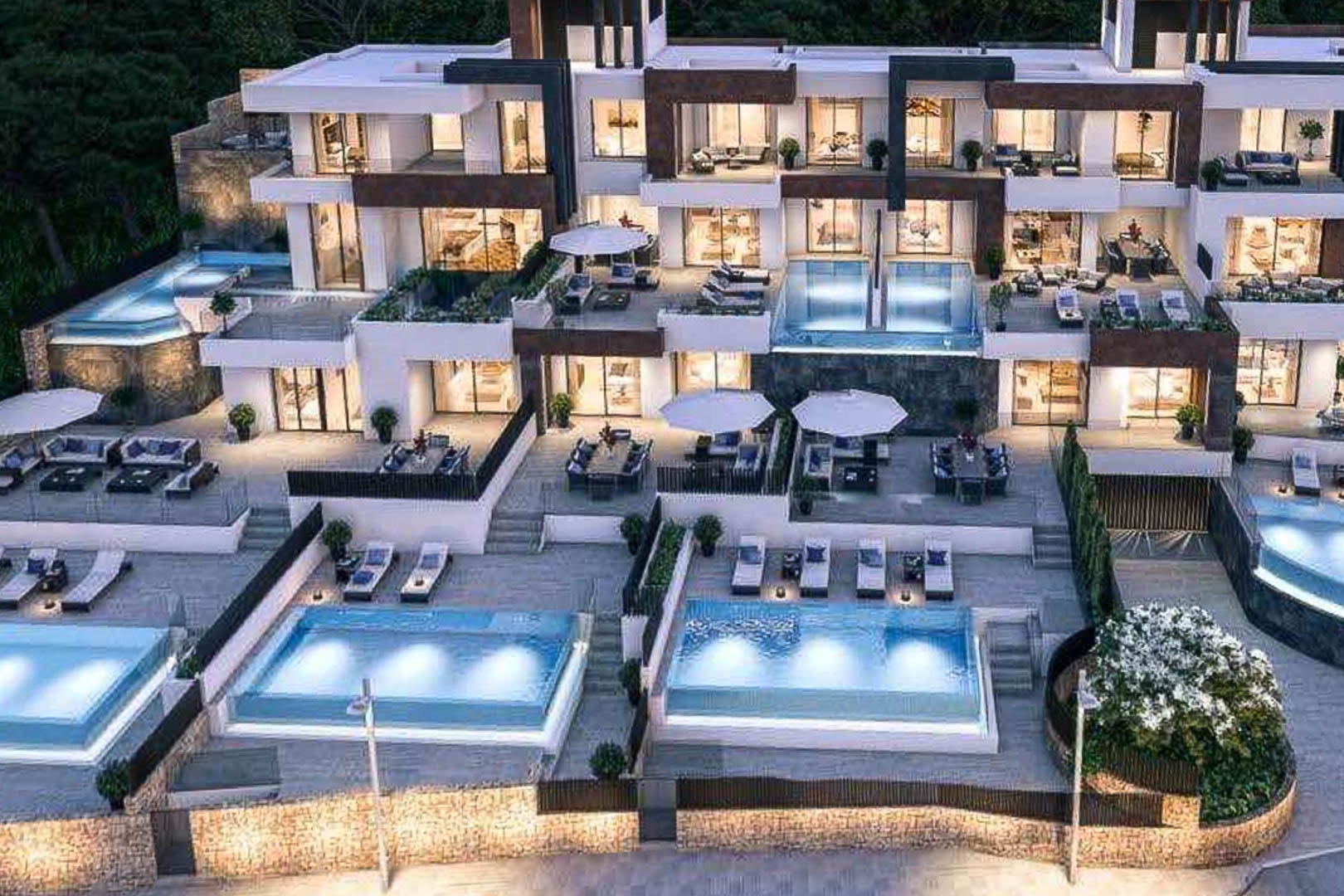 Vue extérieure d'un complexe résidentiel moderne avec terrasses en cascade, piscines privées éclairées et façades alliant pierre naturelle et finitions blanches.