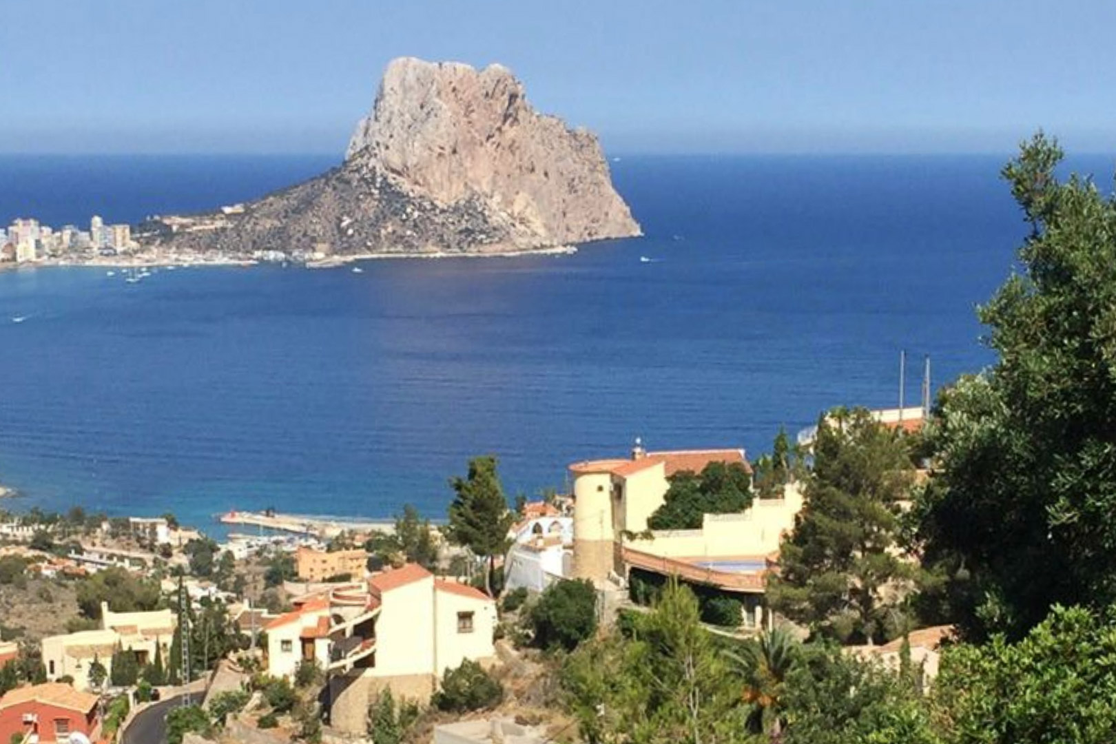 Vue panoramique surélevée sur le Peñón de Ifach et la mer Méditerranée, dominant le paysage résidentiel et la végétation luxuriante de Calpe.