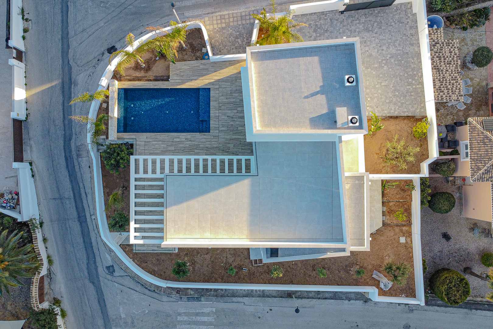 Vue aérienne d'une villa moderne à Benimeit avec piscine bleue et terrasses carrelées grises.