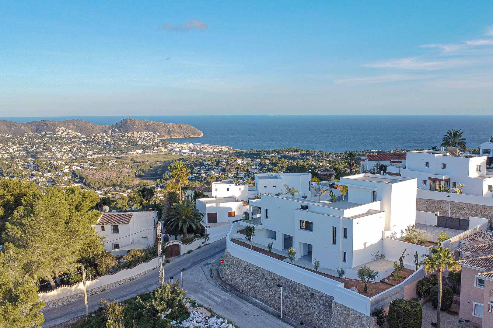 Vue élevée de villas blanches modernes à Benimeit avec vue panoramique sur la mer et la côte.