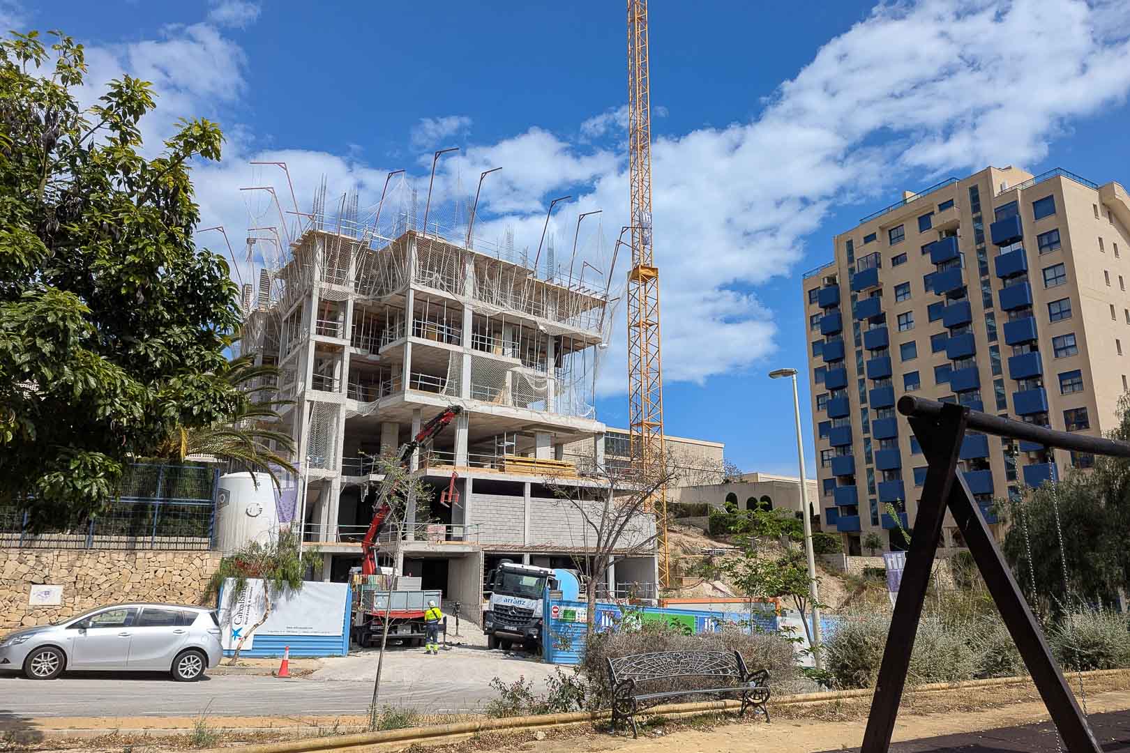 État d'avancement des travaux à Calpe, montrant la structure en béton armé, la grue de chantier et le développement des différents étages résidentiels.