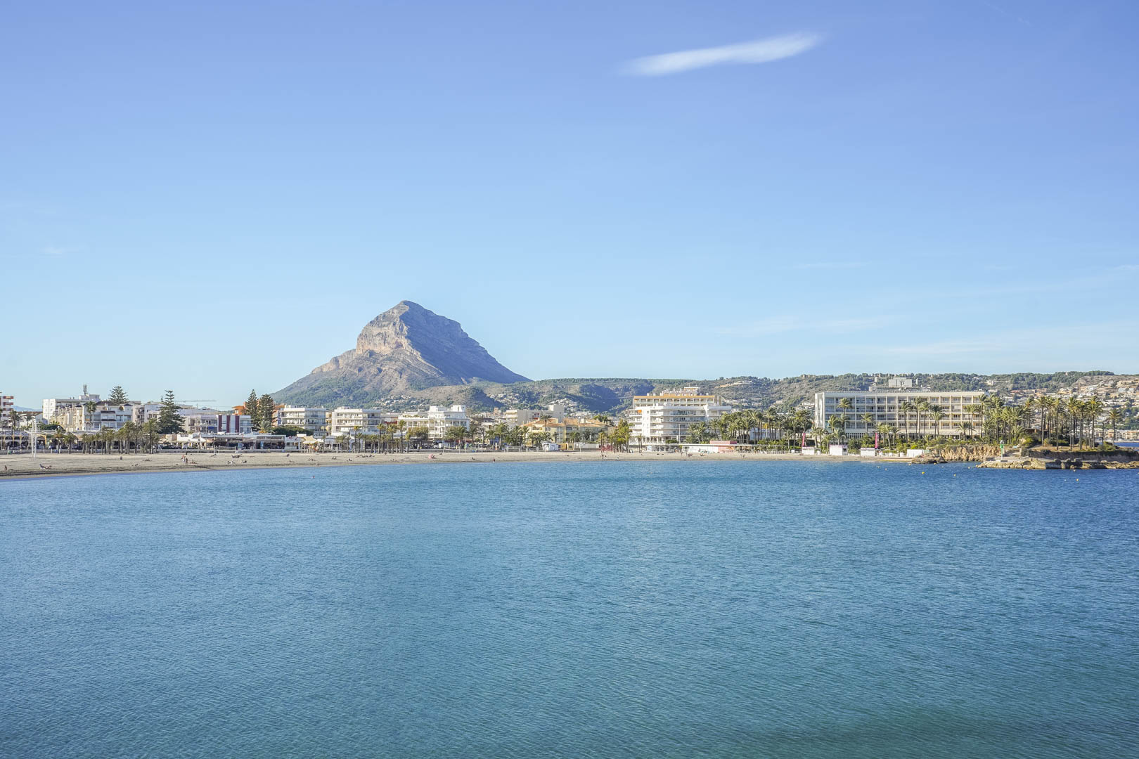 Vue panoramique sur la baie de Jávea avec le Montgó en arrière-plan, illustrant la proximité de la côte et les eaux cristallines de la Méditerranée.