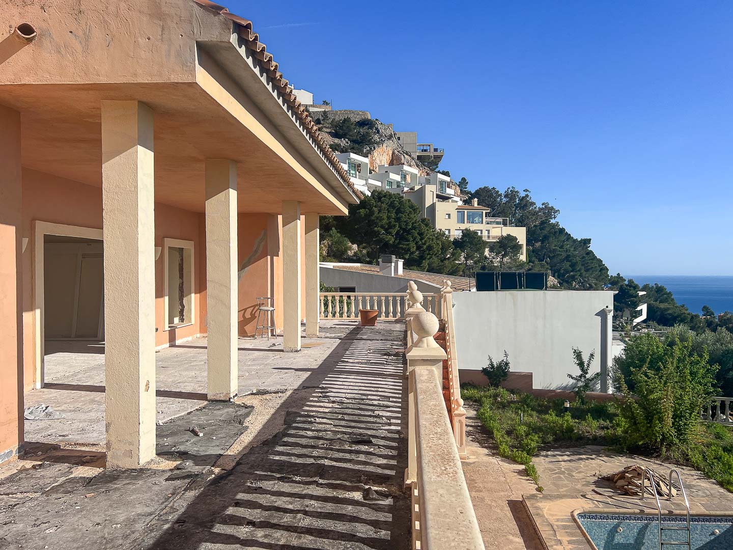 Terrasse extérieure en rénovation avec colonnes structurelles, balustrade classique et vue panoramique sur les collines d'Altea et la mer Méditerranée.