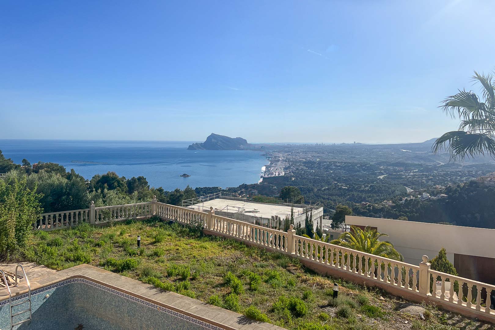 Vues panoramiques sur la mer Méditerranée et le Peñón de Ifach depuis l'espace extérieur avec balustrade en pierre et jardin.