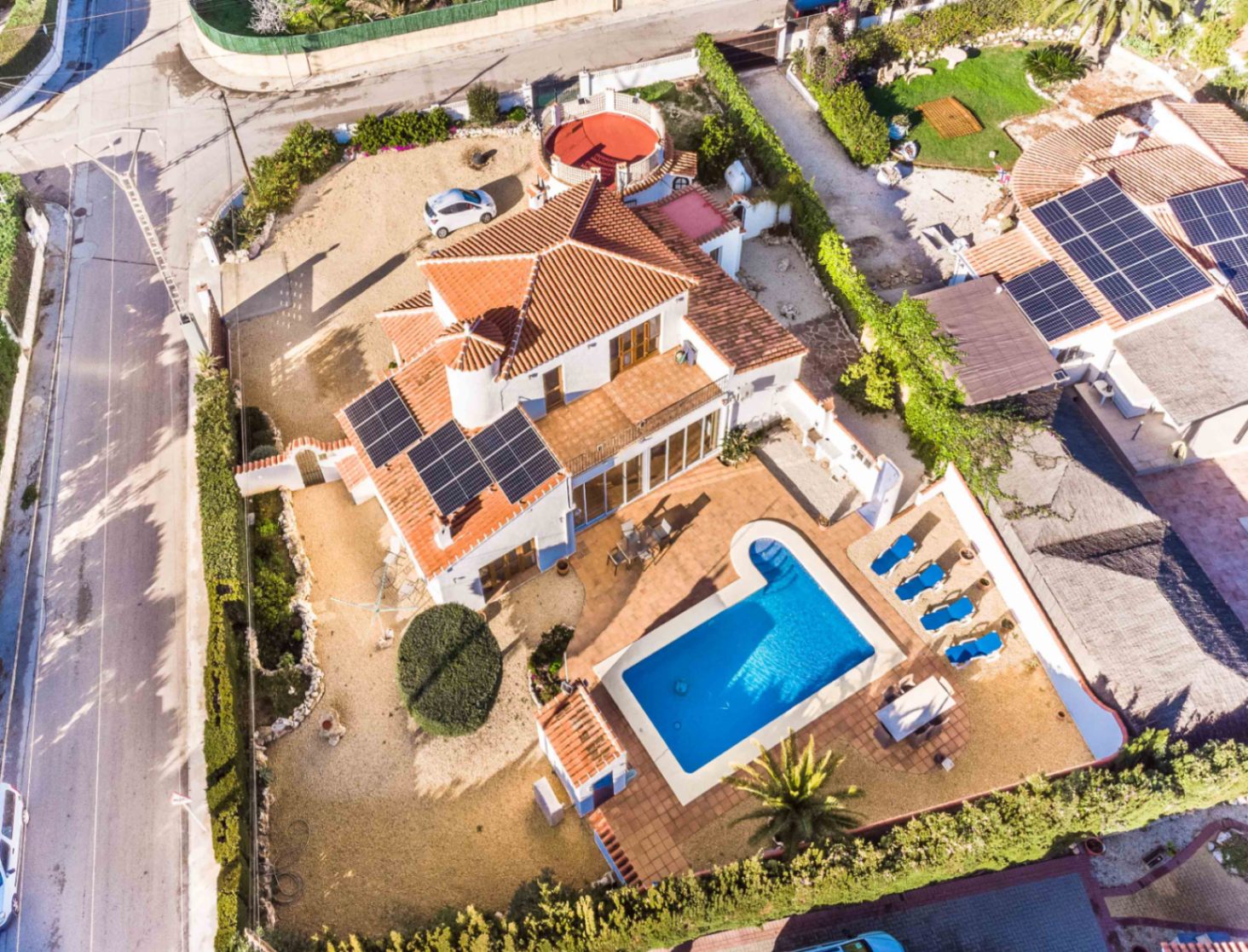 Vue aérienne de la villa méditerranéenne avec panneaux solaires, piscine privée, terrasses ensoleillées et jardin clos avec aménagement en gravier.
