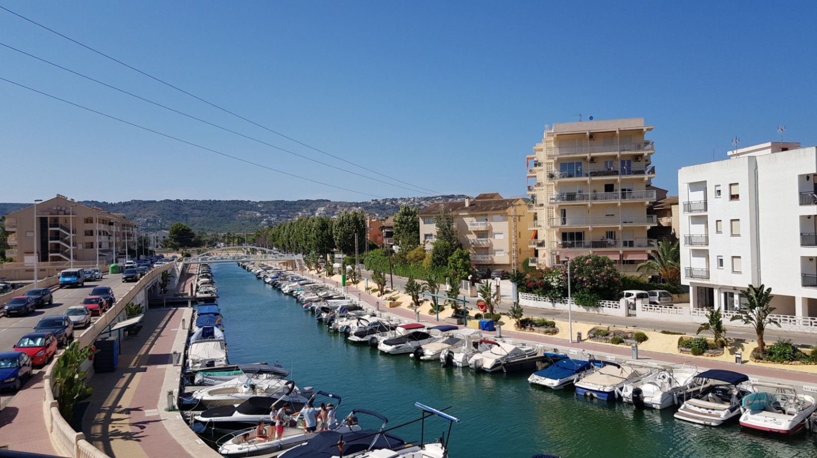 Vue panoramique sur le canal de la Fontana avec ses bateaux de plaisance amarrés, bordé d'immeubles résidentiels et d'un paysage urbain méditerranéen.