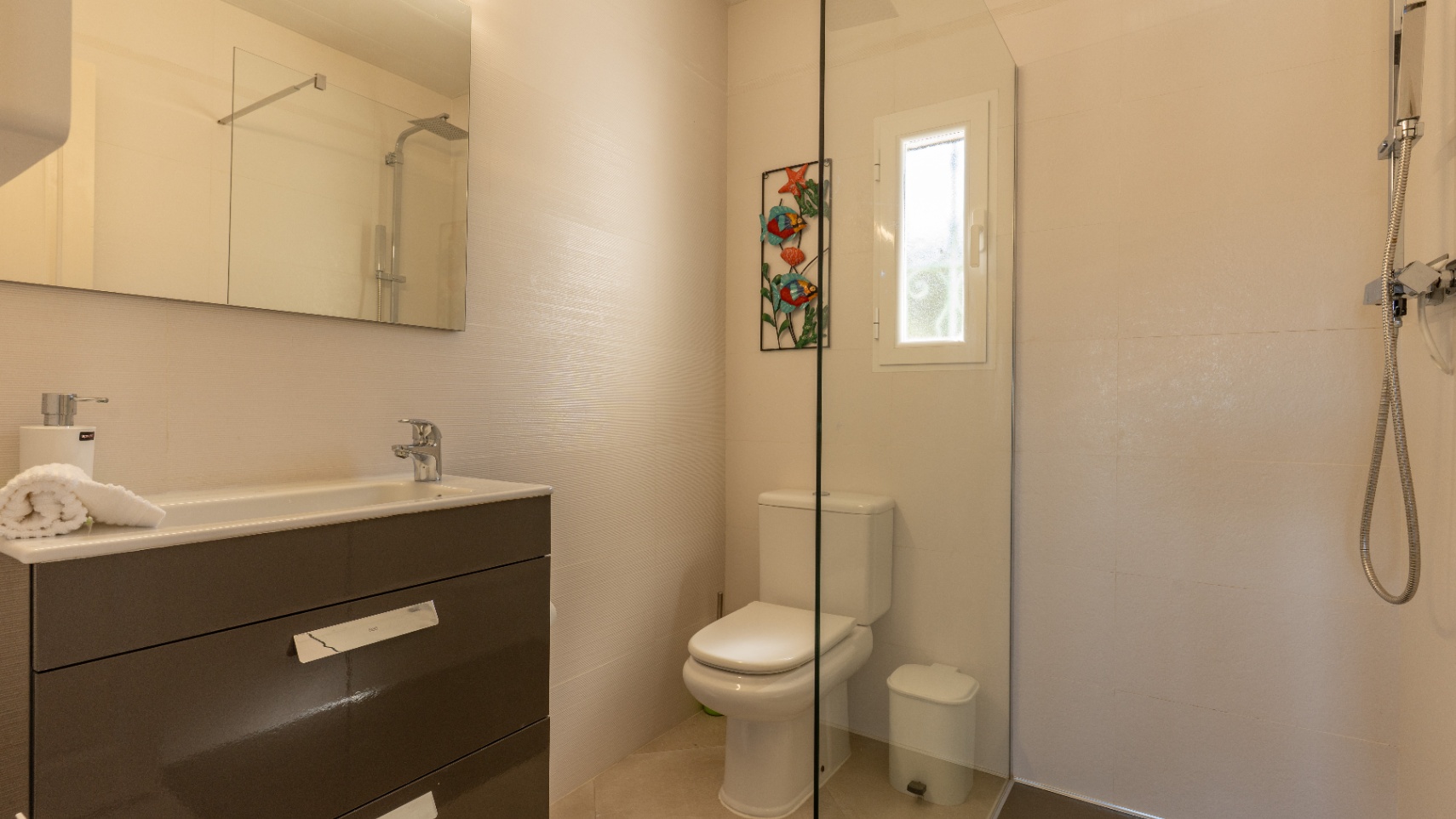 Salle de bains moderne avec meuble vasque gris foncé, grand miroir et douche à l'italienne avec paroi en verre et robinetterie chromée.