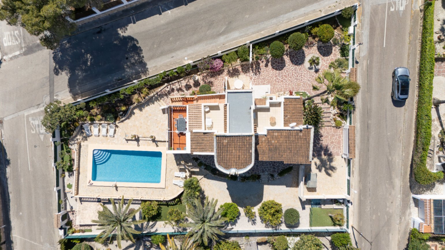 Vue aérienne de la propriété montrant le terrain de 1030 m², la piscine privée avec son solarium, les jardins paysagers et l'architecture de la villa avec ses terrasses.