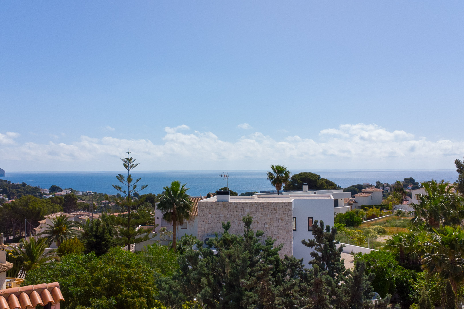 Vue panoramique depuis la propriété sur la mer Méditerranée, mettant en avant l'architecture blanche et la végétation locale luxuriante de Benissa.