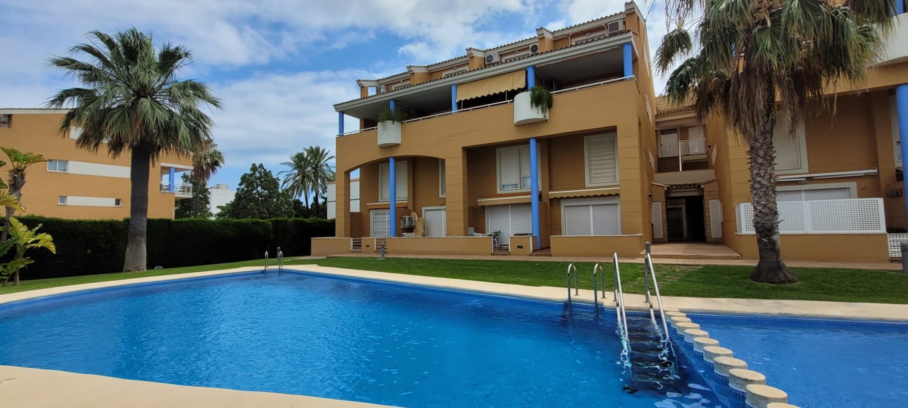 La piscine communautaire accueillante aux eaux bleues claires, entourée d'une pelouse bien entretenue et de palmiers, complète la façade ocre du bâtiment avec des piliers de balcon bleus. La piscine communautaire accueillante aux eaux bleues claires, entourée d'une pelouse bien entretenue et de palmiers, complète la façade ocre du bâtiment avec des piliers de balcon bleus.