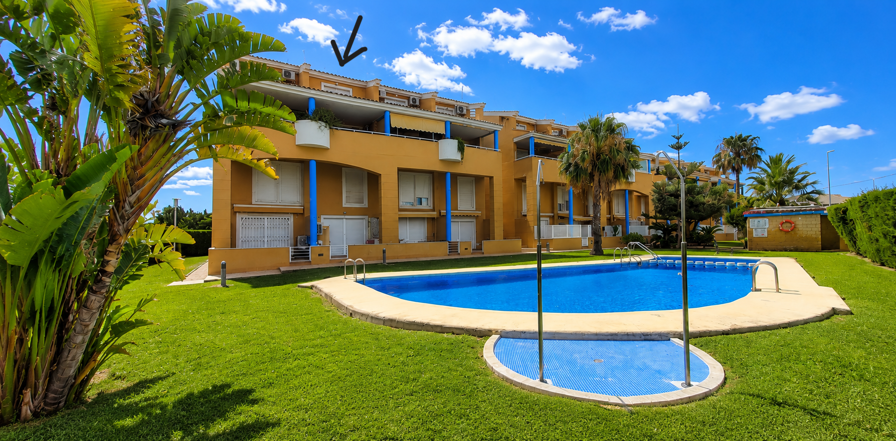 L'immeuble jaune de la communauté, avec piliers bleus, volets blancs et balcons, donne sur la grande piscine communautaire et les jardins entretenus. Le duplex est au dernier étage. L'immeuble jaune de la communauté, avec piliers bleus, volets blancs et balcons, donne sur la grande piscine communautaire et les jardins entretenus. Le duplex est au dernier étage.