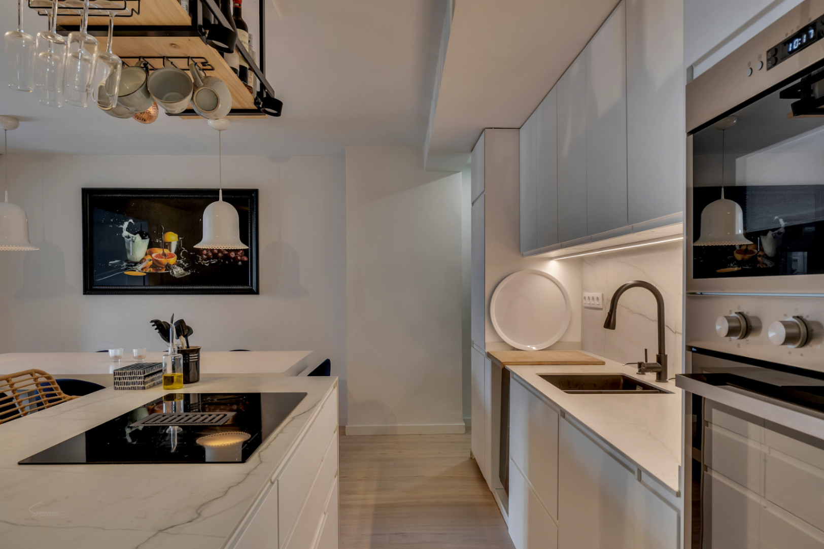 Détail de la cuisine avec îlot central, comptoirs en marbre et électroménagers intégrés.