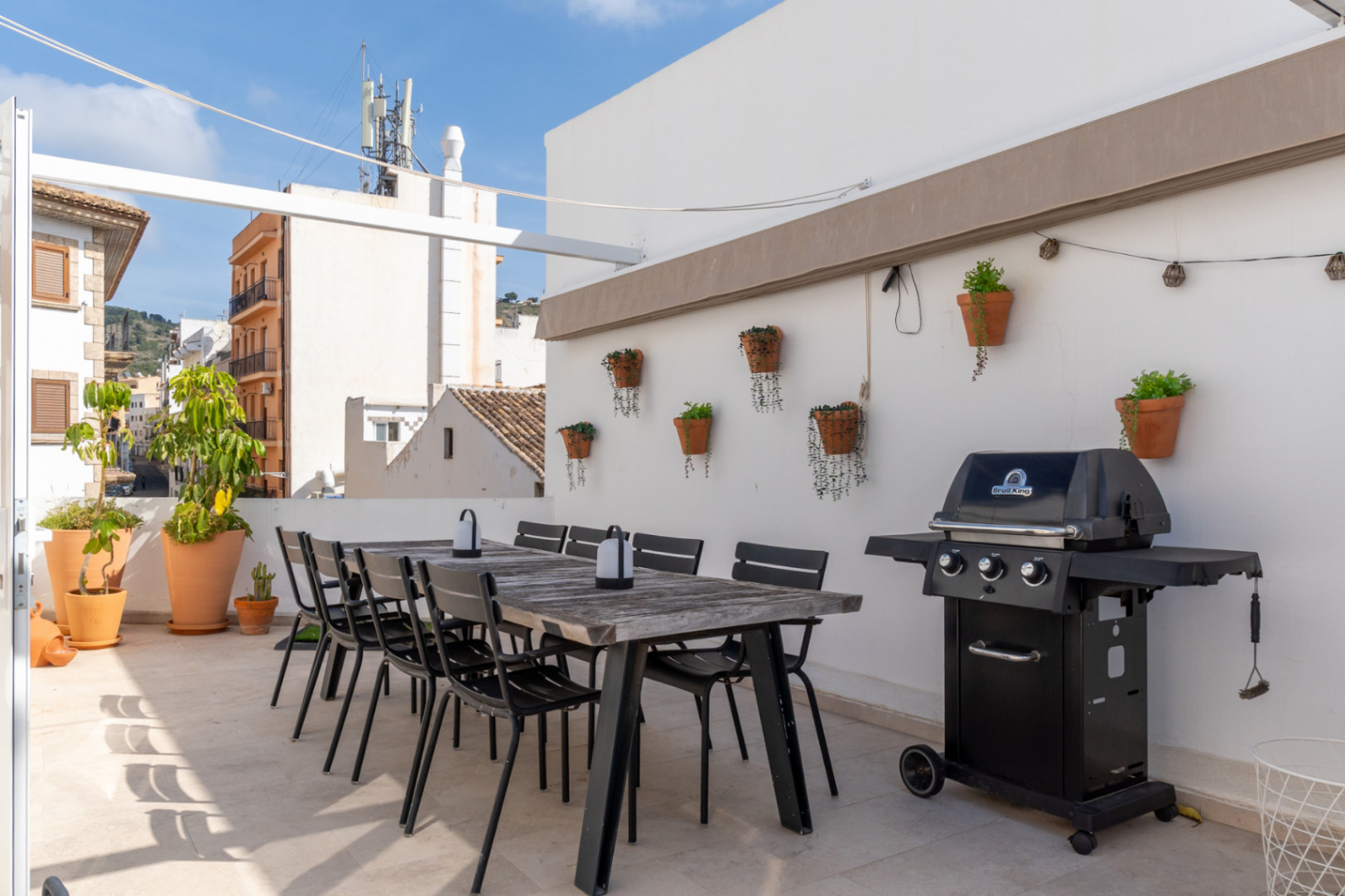 Terrasse avec salle à manger extérieure, barbecue et vue sur la vieille ville de Jávea.