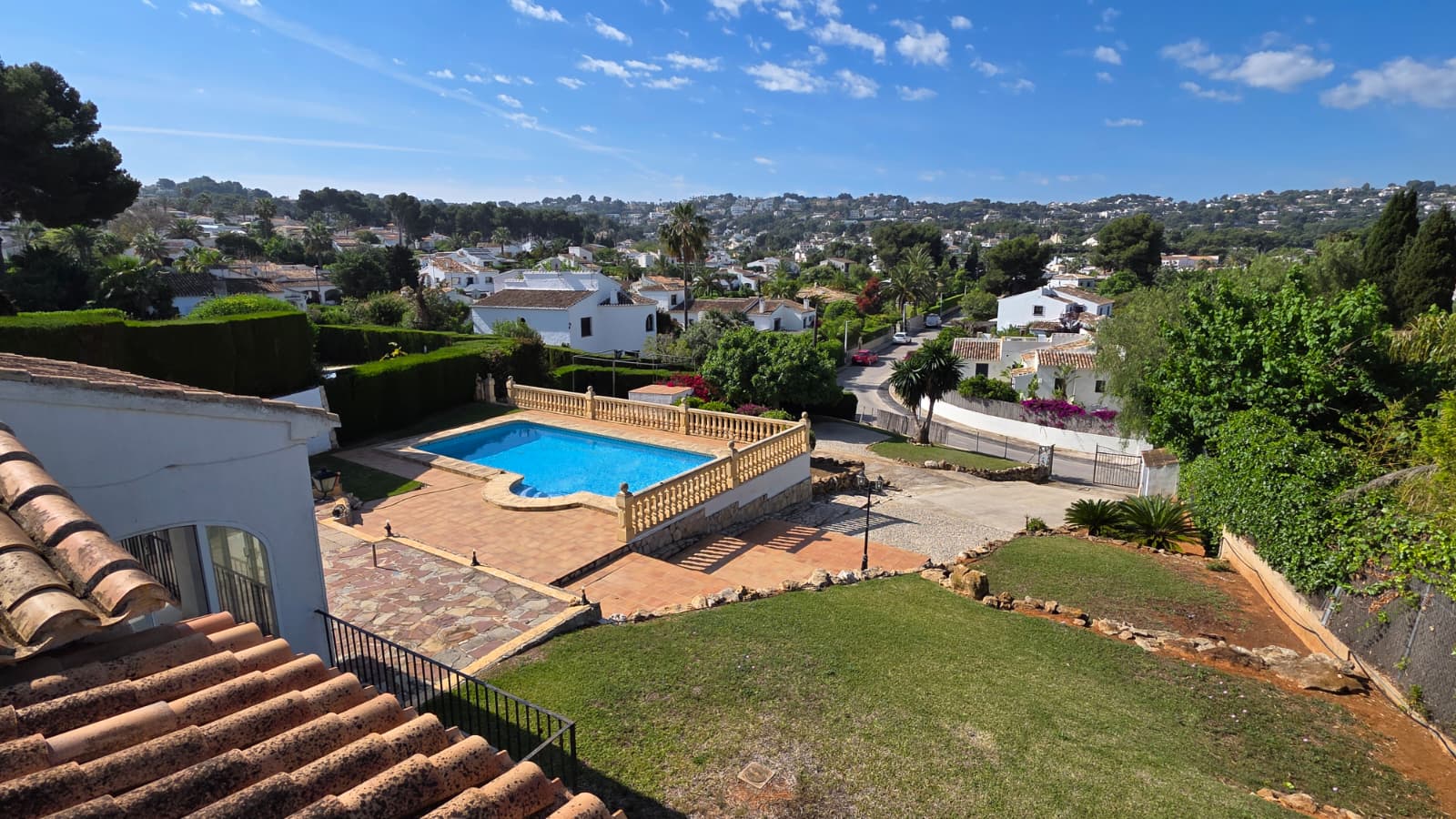 Vue surélevée sur la piscine privée avec balustrade en pierre, terrasse en terre cuite et jardin, offrant une vue dégagée sur le quartier d'El Tosalet.