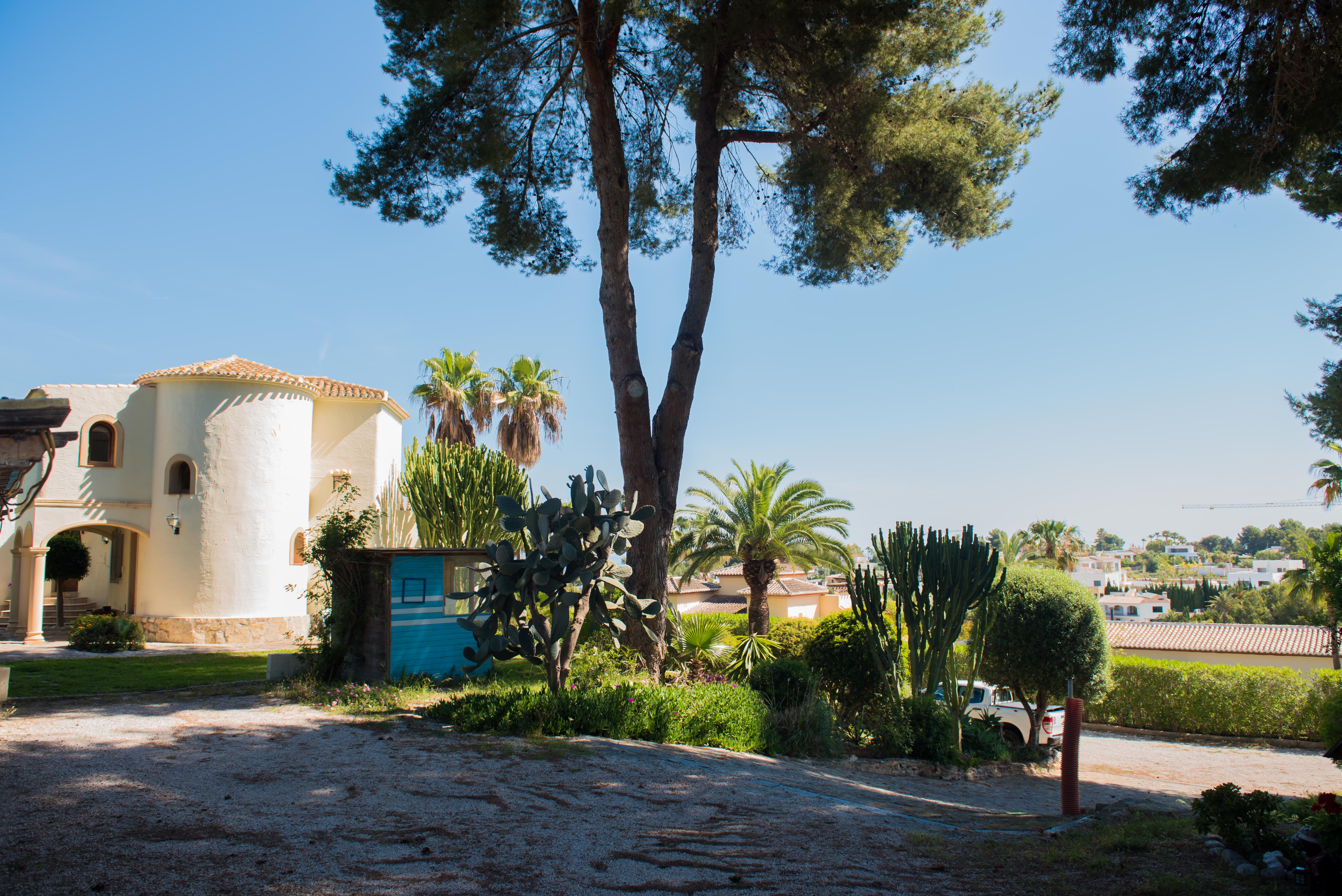 Vue extérieure de la villa méditerranéenne, avec des détails architecturaux uniques et des jardins luxuriants.
