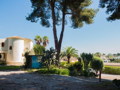 Vue extérieure de la villa méditerranéenne, avec des détails architecturaux uniques et des jardins luxuriants.