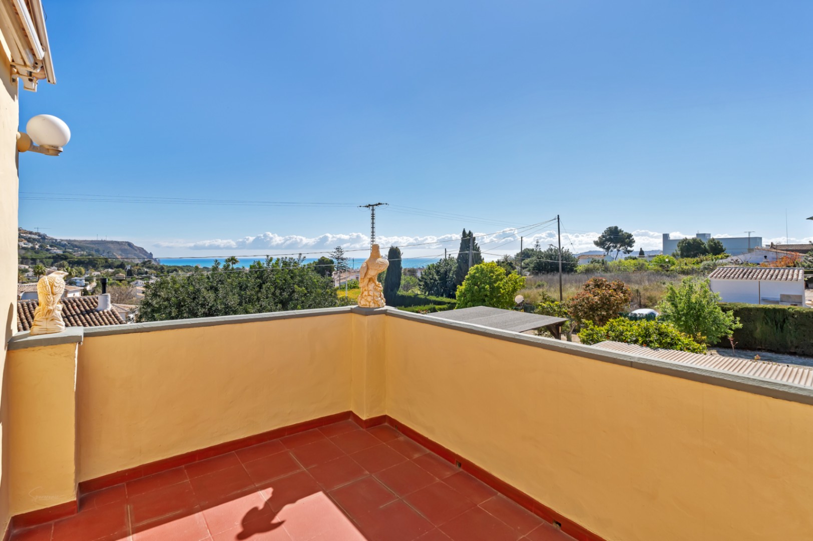 Terrasse surélevée avec sol en terre cuite offrant une vue panoramique sur la mer Méditerranée et les paysages environnants.