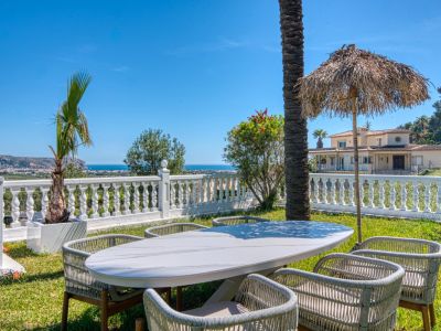 Salle à manger extérieure avec table en marbre et vue sur la mer Méditerranée depuis le jardin de la villa.