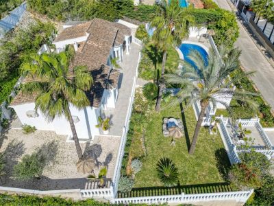 Vue aérienne de la villa avec jardin, piscine et terrasse. Conception méditerranéenne avec murs blancs et végétation luxuriante.