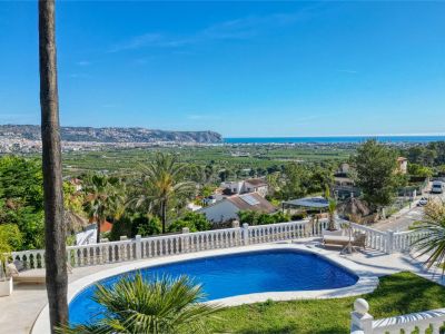 Vue surélevée de la piscine avec rambarde blanche et vue panoramique sur la mer et la ville.