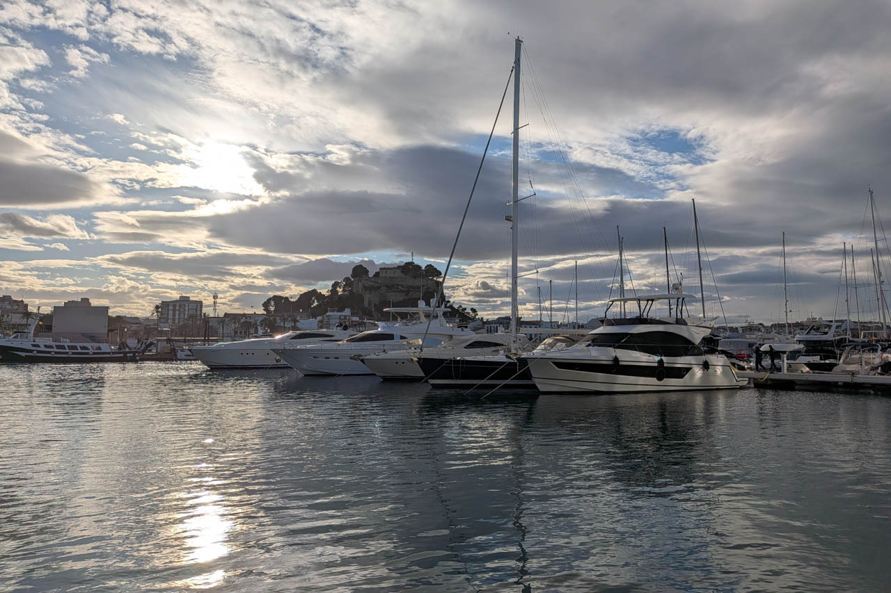 Vue sur la marina avec des yachts et des reflets du soleil sur l'eau.