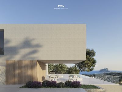 Vue extérieure de la villa avec façade en brique claire et terrasse avec vue sur la mer.