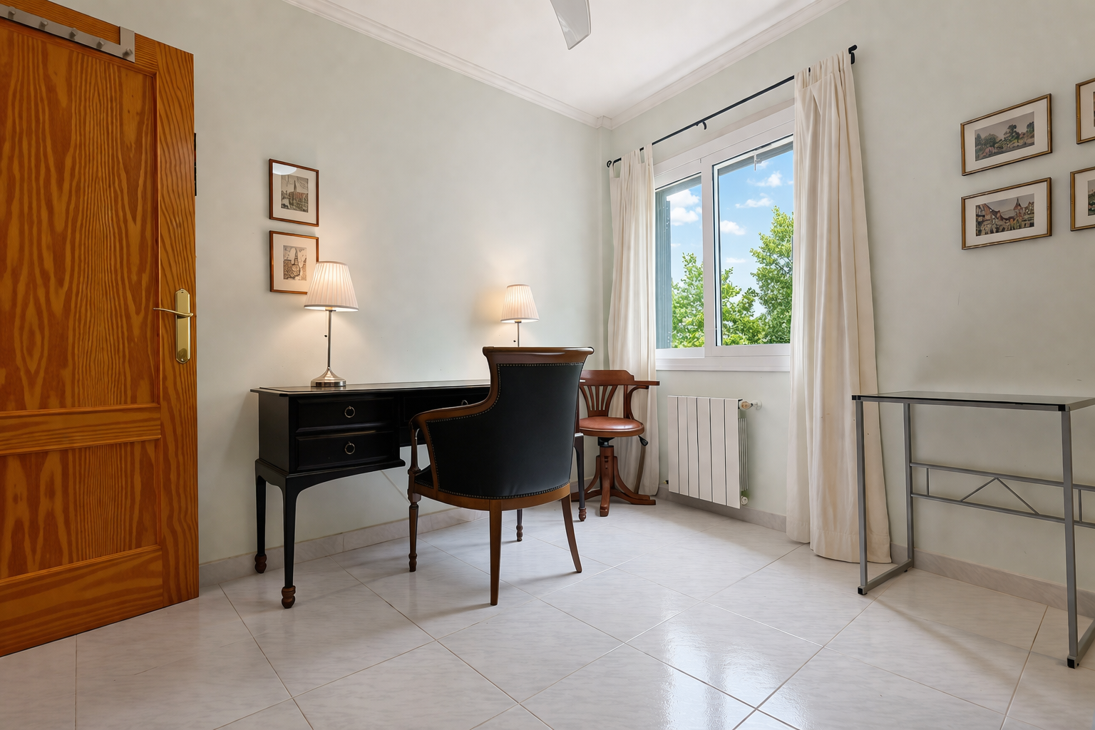 Chambre lumineuse avec bureau classique en bois foncé et chaise rembourrée, idéale pour un bureau ou un espace de travail.