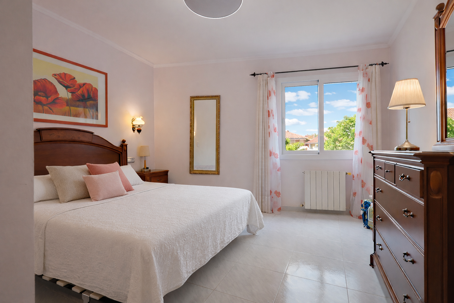 Chambre lumineuse avec lit en bois, commode classique et vue sur l'extérieur.