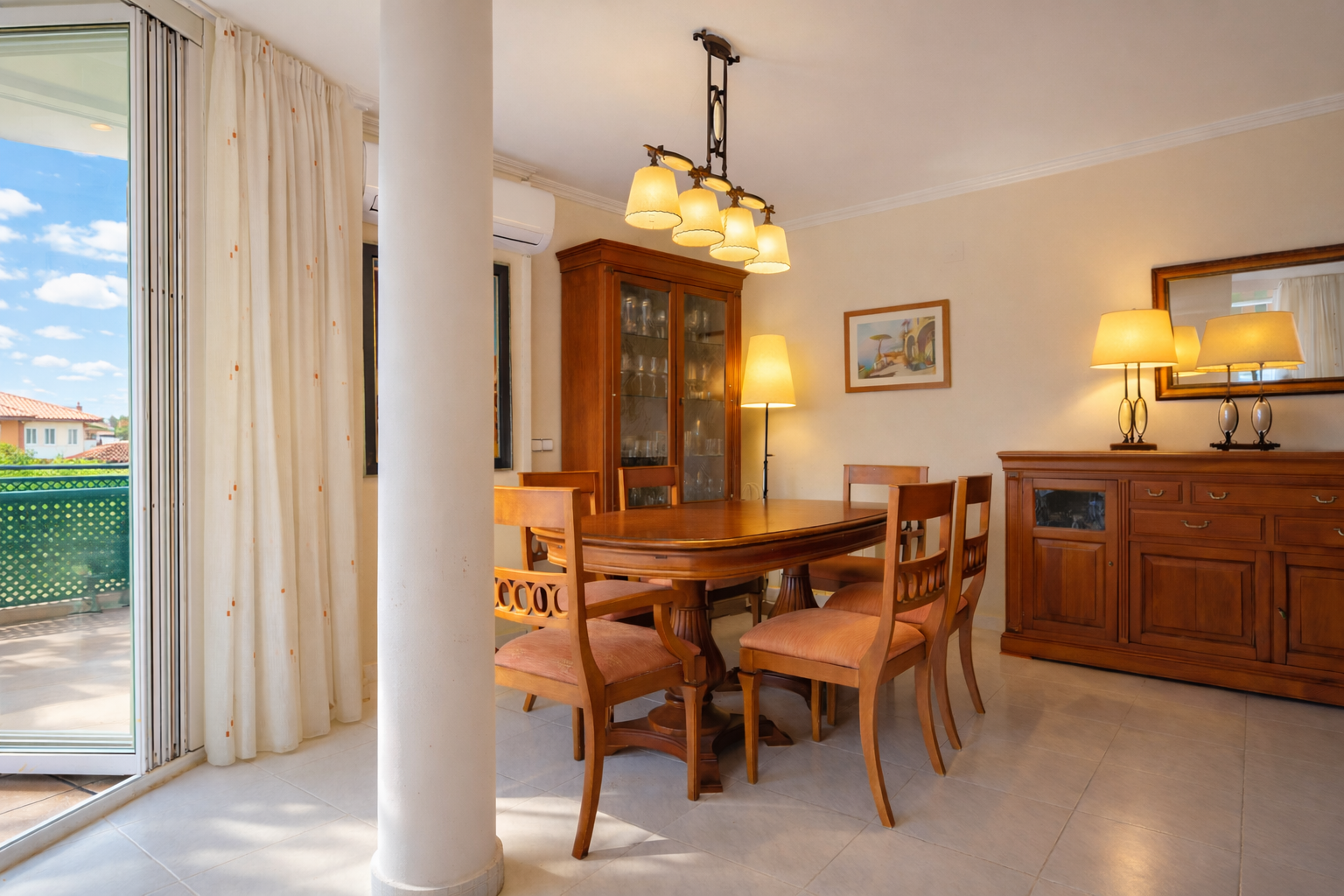 Salle à manger lumineuse avec table en bois, vitrine et accès à une terrasse extérieure.