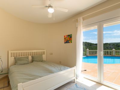Chambre lumineuse avec accès direct à la piscine et ventilateur de plafond.