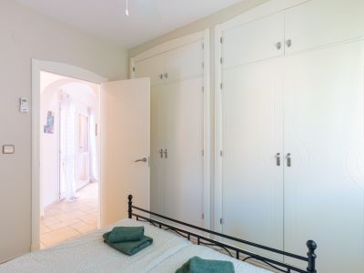 Chambre lumineuse avec placard intégré design et accès à une terrasse.