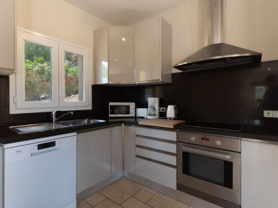 Cuisine moderne avec comptoir noir et appareils en acier inoxydable.